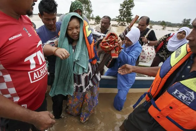 A pregnant woman is evacuated from her home by rescue workers as she is taken to a hospital, on the outskirts of Kota Bharu December 29, 2014. (Photo by Athit Perawongmetha/Reuters)