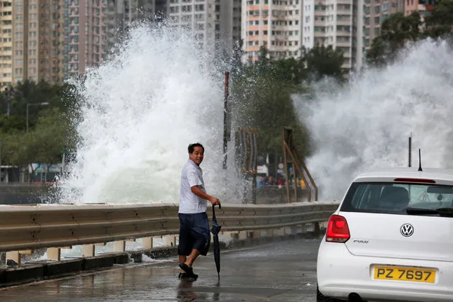 A man looks on while walking in front of big waves along a waterfront as Typhoon Haima approaches in Hong Kong, China, October 21, 2016. (Photo by Bobby Yip/Reuters)