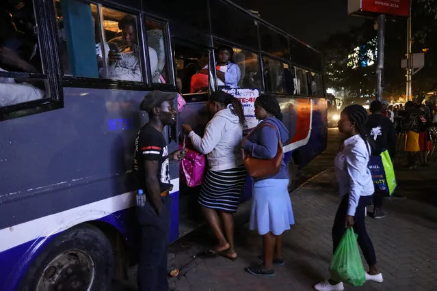Passengers board a corporate owned bus at night in the streets of Nairobi, Kenya, 24 March 2018. (Photo by Daniel Irungu/EPA/EFE)