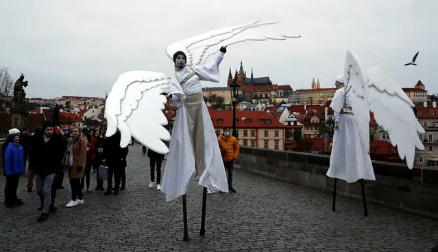 Men dressed as angels walk across the medieval Charles Bridge amid the coronavirus disease (COVID-19) outbreak in Prague, Czech Republic, December 20, 2020. (Photo by David W. Cerny/Reuters)