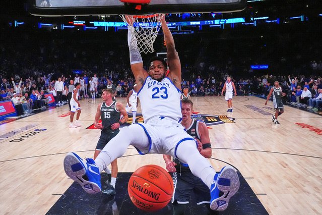 Kentucky's Mouhamed Dioubate, center, dunks the ball in front of Michigan State's Jaxon Kohler, right, and Carson Cooper, left, during the first half of an NCAA college basketball game Tuesday, November 18, 2025, in New York. (Photo by Frank Franklin II/AP Photo)