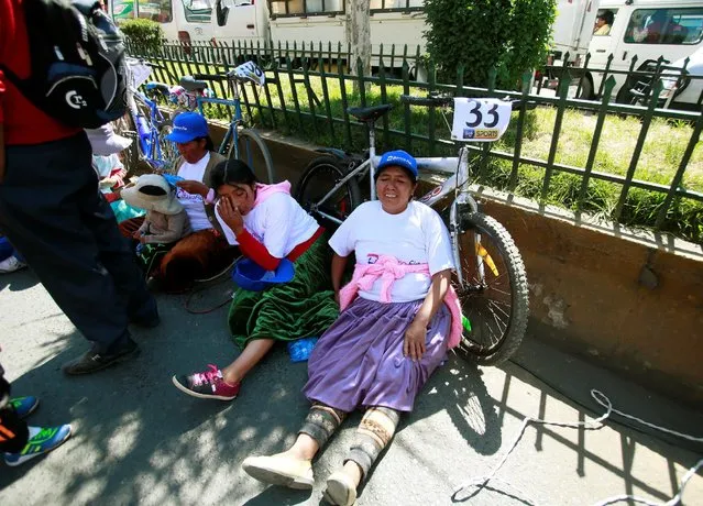 Participants rest after finishing the Cholita bike race in El Alto, on the outskirts of La Paz, Bolivia, October 29, 2016. (Photo by David Mercado/Reuters)