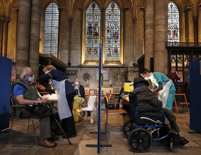 People recieve their Pfizer-BioNTech vaccination inside Salisbury Cathedral in Salisbury, England, Wednesday, January 20, 2021. Salisbury Cathedral opened its doors for the second time as a venue for the Sarum South Primary Care Network COVID-19 Local Vaccination Service. (Photo by Frank Augstein/AP Photo)