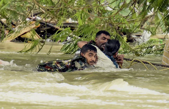 Indian army soldiers rescue a man from flood waters in Chennai, India, Thursday, December 3, 2015. The heaviest rainfall in more than 100 years has devastated swathes of the southern Indian state of Tamil Nadu, with thousands forced to leave their submerged homes and schools, offices and a regional airport shut for a second day Thursday. (Photo by R. Senthil Kumar/Press Trust of India via AP Photo)