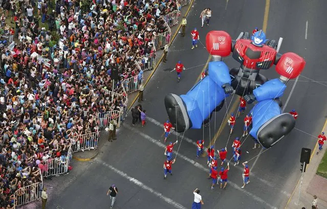 The Optimus Prime balloon makes its way along the streets during an annual Christmas parade at Santiago town in Chile, December 13, 2015. (Photo by Pablo Sanhueza/Reuters)