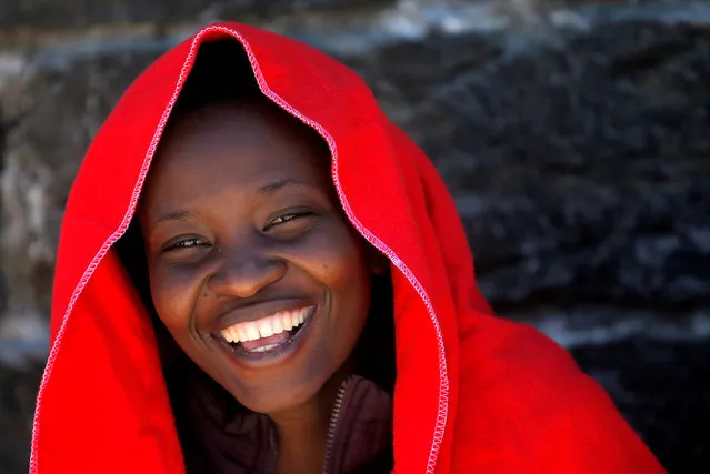 A migrant intercepted aboard a dinghy off the coast in the Strait of Gibraltar, smiles as she rests after arriving on a rescue boat at the port of Tarifa, southern Spain July 1, 2018. (Photo by Jon Nazca/Reuters)