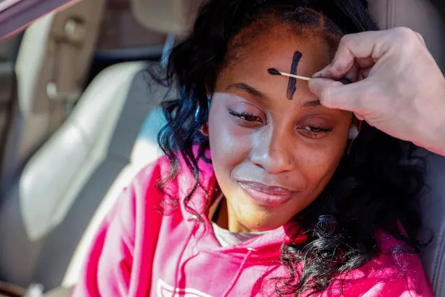 Father Bryan Small ashes Netanya Lattimore's forehead at a drive-thru Ash Wednesday service at Saints Peter and Paul Catholic Church in Atlanta, Georgia, U.S. February 17, 2021. (Photo by Chris Aluka Berry/Reuters)