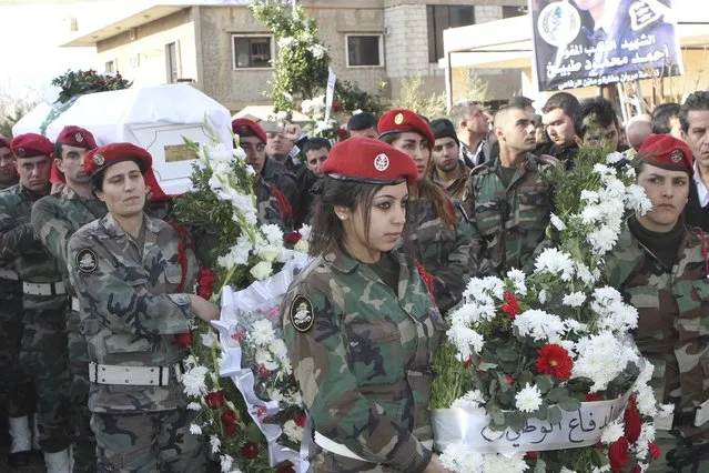 Lebanese soldiers carry the coffin of Lebanese soldier Lieutenant Ahmad Mahmud Tabikh during his funeral in Doures, Baalbek January 24, 2015. The Lebanese army said on Saturday three more soldiers were killed in fighting on Friday between troops and militants who attacked an army post near the border with Syria. The army said on Friday it lost five soldiers, including Tabikh, in an attack near the village of Ras Baalbek in an area that has seen regular incursions by Islamist militants fighting in Syria. (Photo by Ahmad Shalha/Reuters)