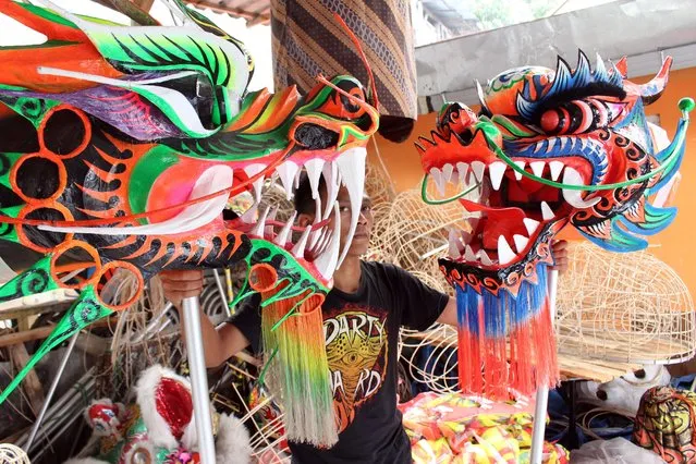 An Indonesian worker checks two dragons masks for the upcoming Lunar New Year at a traditional Chinese dragon and lion masks and custome maker in Bogor, Indonesia, 02 February 2015. (Photo by Adi Weda/EPA)