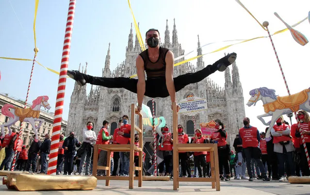 A fun fair and circus performer takes part in a demonstration against coronavirus restrictions in Milan, Italy, 26 March 2021. The entertainment industry is hit hard by the Italian government's COVID-19-linked restrictions. (Photo by Matteo Bazzi/EPA/EFE)