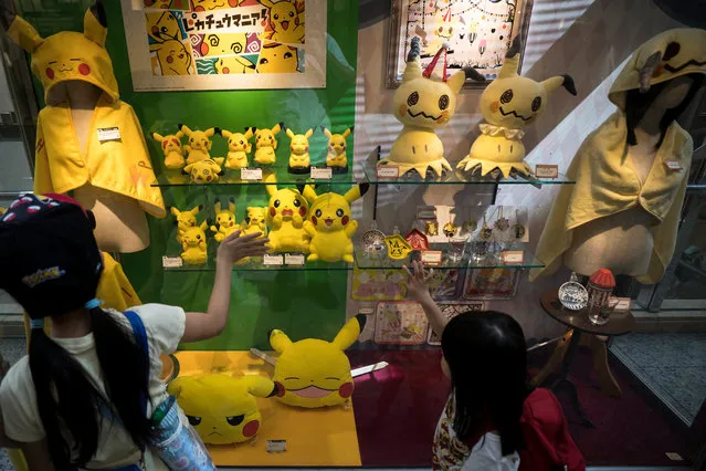 Girls look at plush toys of Pikachu, a character from Pokemon series game titles, at a shopping mall during the Pikachu Outbreak event hosted by The Pokemon Co. on August 10, 2018 in Yokohama, Kanagawa, Japan. (Photo by Tomohiro Ohsumi/Getty Images)