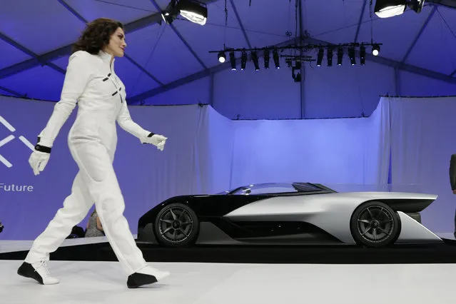A driver walks in front of the FFZero1 by Faraday Future at CES Unveiled, a media preview event for CES International  Monday, January 4, 2016, in Las Vegas. (Photo by Gregory Bull/AP Photo)
