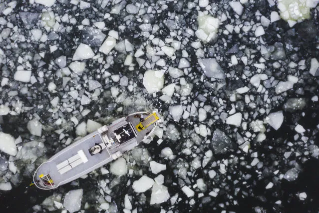 Aerial view shows a boat making its way through the icy water of Lidingo, near Stockholm, Sweden, on February 22, 2021. (Photo by Jonathan Nackstrand/AFP Photo)