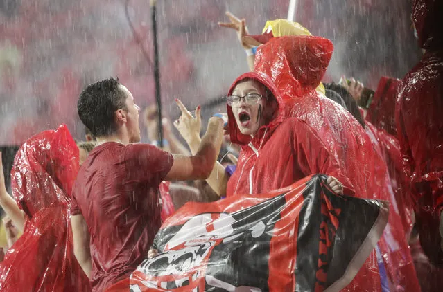 Fans at Memorial Stadium dance to music during a lightning and rain delay in the first half of an NCAA college football game between Nebraska and Akron in Lincoln, Neb., Saturday, September 1, 2018. (Photo by Nati Harnik/AP Photo)
