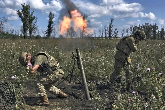 Ukrainian soldiers fire a mortar towards Russian positions at the front line, near Bakhmut, Donetsk region, Ukraine, Saturday, August 12 2023. (Photo by Libkos/AP Photo)