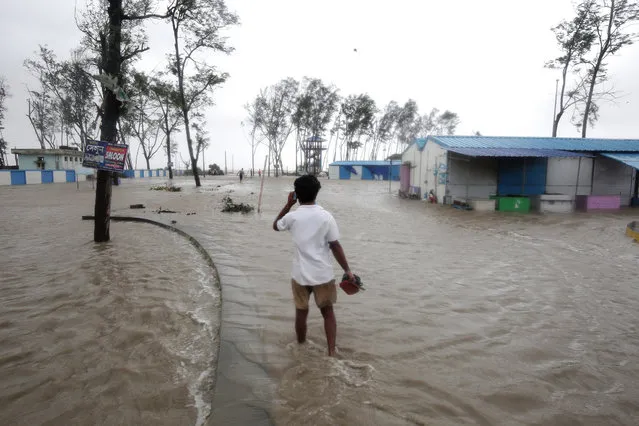 A man walks through a flooded area as Cyclone Yaas makes landfall in Digha, near the Bay of Bengal, south of Kolkata, India, 26 May 2021. (Photo by Piyal Adhikary/EPA/EFE)