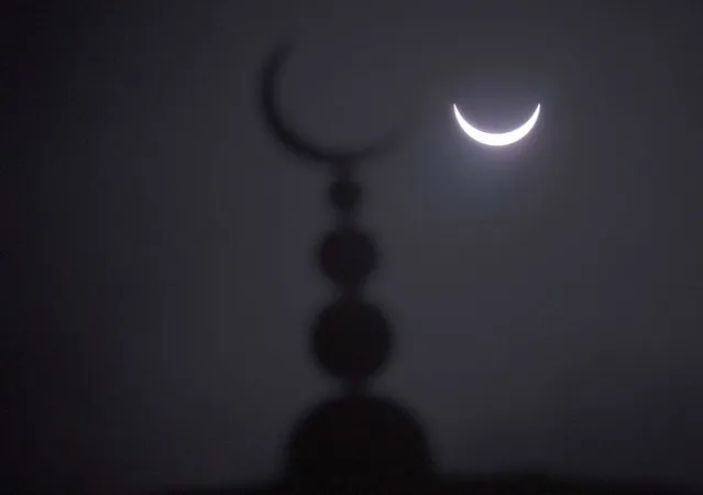 A partial solar eclipse in seen above a mosque in Oxford, central England March 20, 2015. (Photo by Eddie Keogh/Reuters)