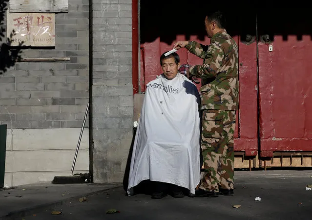 A man has a haircut outdoor as blue sky returns after winds dispelled dangerously high levels of air pollution in Beijing, China December 22, 2016. (Photo by Jason Lee/Reuters)
