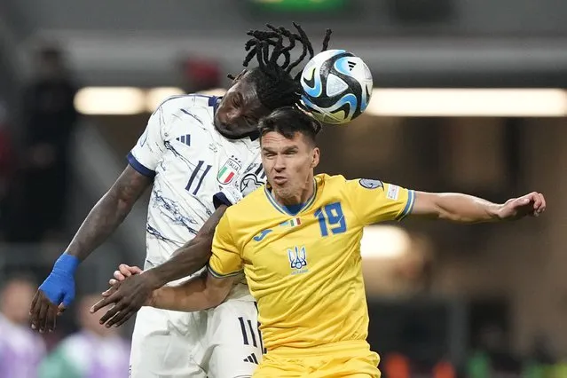 Italy's Moise Kean, left, jumps for a header with Ukraine's Oleksandr Tymchyk during the Euro 2024 group C qualifying soccer match between Ukraine and Italy at the BayArena in Leverkusen, Germany, Monday, November 20, 2023. (Photo by Martin Meissner/AP Photo)