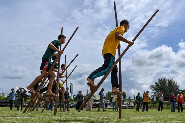 Participants compete in a traditional game as part of the Aceh Festival Week in Banda Aceh on November 7, 2023. (Photo by Chaideer Mahyuddin/AFP Photo)