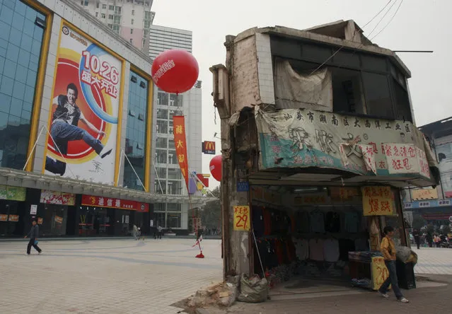 A “nail house”, the last house in this area, stands on the square in front of a shopping mall in Changsha, central China's Hunan province, November 13, 2007. “Nail houses” refer to houses whose owners have stuck to their ground and resisted demolition, holding up development projects in the world's fastest-growing major economy. (Photo by Reuters/Stringer)