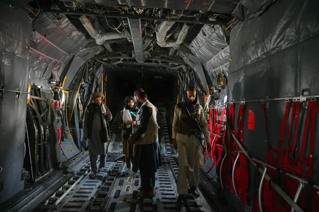 Taliban fighters stand inside an Afghan Air Force aircraft at the airport in Kabul on August 31, 2021. (Photo by Wakil Kohsar/AFP Photo)