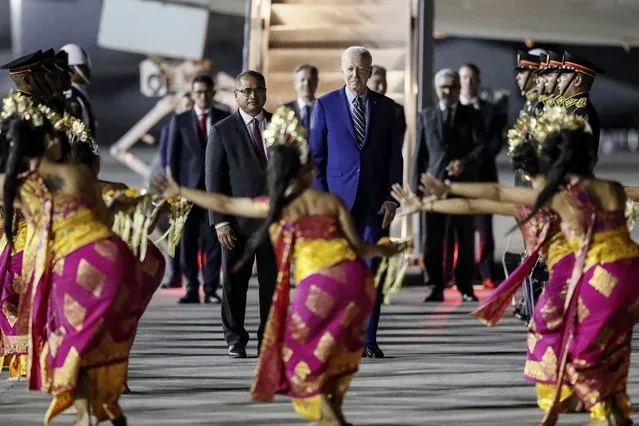 U.S. President Joe Biden, center, watches Balinese dancers perform upon his arrival to attend the G20 Summit at the Ngurah Rai International Airport in Bali, Indonesia, Sunday, November 13, 2022. (Photo by Made Nagi/Pool Photo via AP Photo)