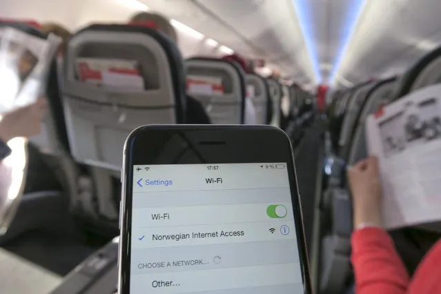 A mobile phone is connected to Wi-Fi network on board a Norwegian Airways Boeing 737-800 at Berlin Schoenefeld Airport in this April 2, 2015 file photo. Panasonic Avionics says it will need to double the rate at which it installs Wi-Fi systems on aircaft if it is to catch up with skyrocketing demand from airlines to keep passengers connected above the clouds. (Photo by Pawel Kopczynski/Reuters)