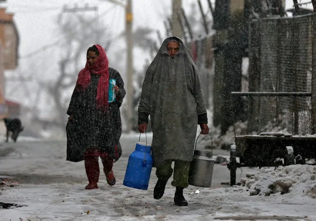 A milkman and a woman walk during a snowfall in Srinagar, India January 17, 2017. (Photo by Danish Ismail/Reuters)