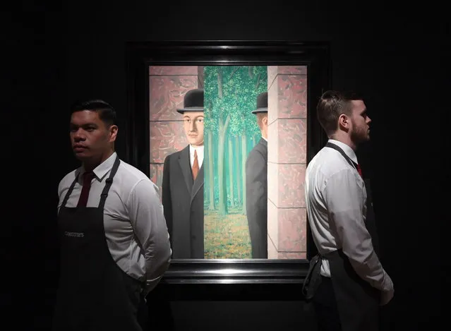 Christie's employees pose next to a painting entitled “Le lieu commun” by Belgian surrealist artist, Rene Magritte, estimated at 15 million GBP (20 million USD), during a press day at Christie's in London, Britain, 21 February 2019. Hidden Treasures: Masterpieces from an Important Private Collection Impressionist and Modern Art sale will take place on 27 February. (Photo by Facundo Arrizabalaga/EPA/EFE)