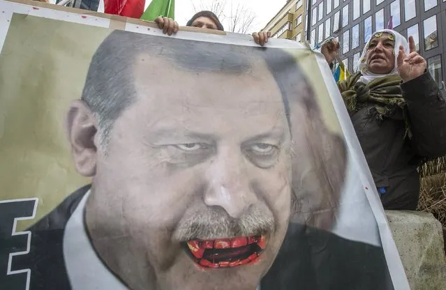 Kurdish people display a picture of Turkish President Tayyip Erdogan during a protest outside an EU-Turkey summit as the bloc is looking to Ankara to help it curb the influx of refugees and migrants flowing into Europe, in Brussels March 7, 2016. (Photo by Yves Herman/Reuters)