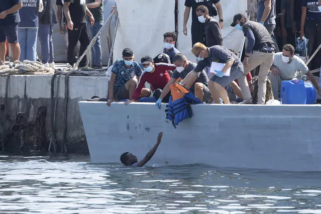 A man asks for assistance as migrants arrive at the Lampedusa island, Italy, Sunday, October 3, 2021. (Photo by Sea-Watch.org/David.Lohmueller via AP Photo)