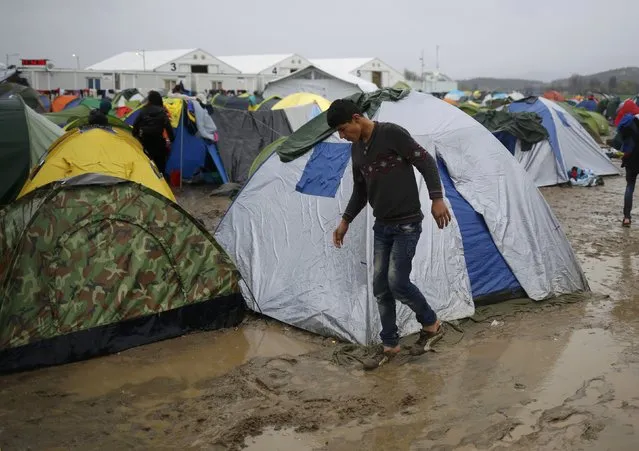 A migrant walks in a mud at a makeshift camp on the Greek-Macedonian border, near the village of Idomeni, Greece March 10, 2016. (Photo by Stoyan Nenov/Reuters)