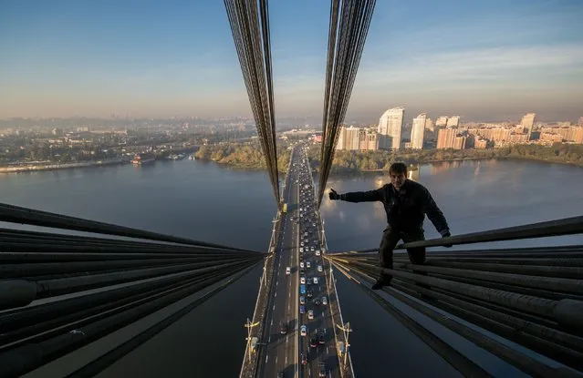 One of Yaroslav Segeda's friends climbs the Moscow Bridge in Kiev. (Photo by Yaroslav Segeda/Solent News)