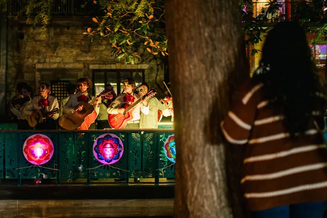 A woman watches a Mariachi band play aboard a float during the Day of the Dead River parade on October 29, 2021 in San Antonio, Texas. People gathered in San Antonio to celebrate, commemorate, and remember departed loved ones for this year's Día de los Muertos. This year's celebration is newly returned after in-person gatherings and festivities were canceled last year due to COVID-19. (Photo by Brandon Bell/Getty Images)