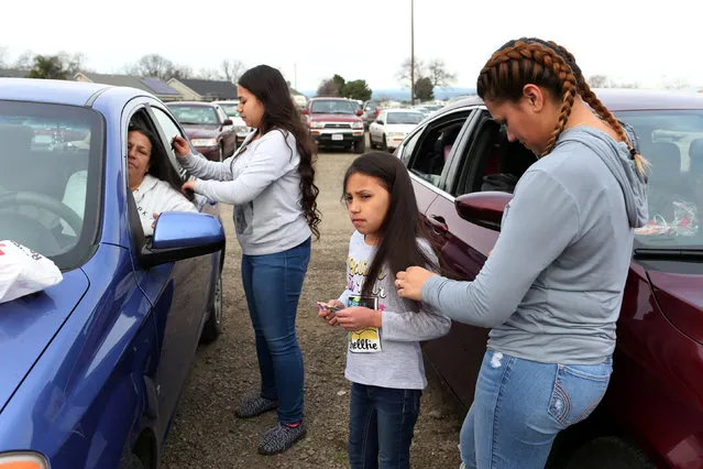 Violet Orozco (2nd R), 9, has her hair brushed by her sister Bertha (R), of Gridley, California, at a Red Cross relief center in Chico, California, after an evacuation was ordered for communities downstream from the Lake Oroville Dam, in Oroville, California, U.S. February 13, 2017. (Photo by Beck Diefenbach/Reuters)