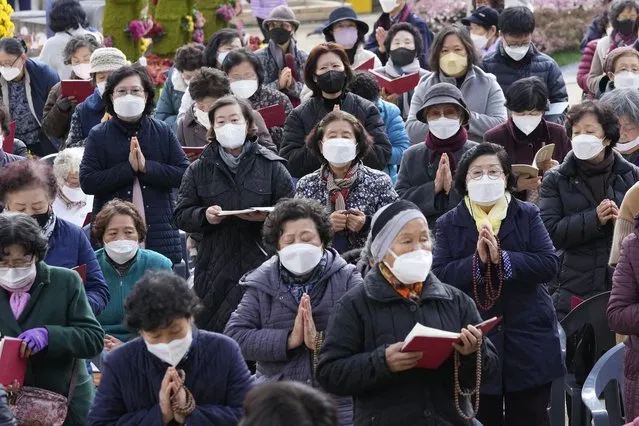 Parents wearing face masks pray during a special service to wish for their children's success on the eve of the college entrance exam at the Jogyesa Buddhist temple in Seoul, South Korea, Wednesday, November 17, 2021. About 500,000 high school seniors and graduates across the country are expected to take the College Scholastic Ability Test. (Photo by Ahn Young-joon/AP Photo)