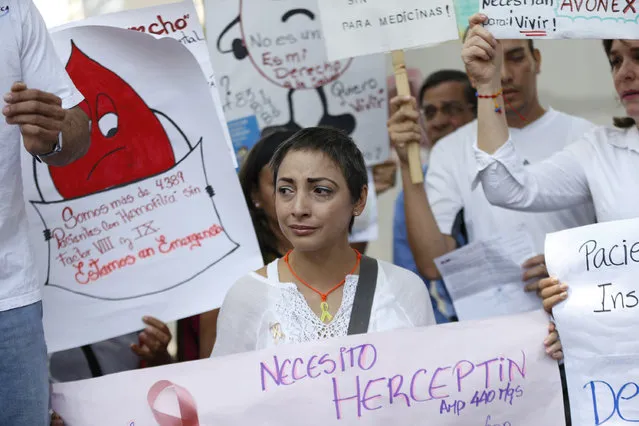 A woman holding a placard cries during a protest due to the lack of medicines in Caracas, Venezuela March 31, 2016. The placard reads, “I need herceptin”. (Photo by Carlos Garcia Rawlins/Reuters)
