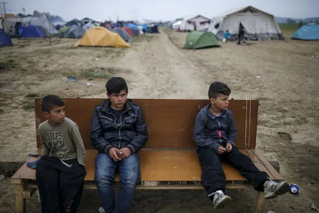 Children sit on a bench at a makeshift camp for migrants and refugees at the Greek-Macedonian border near the village of Idomeni, Greece, April 3, 2016. (Photo by Marko Djurica/Reuters)