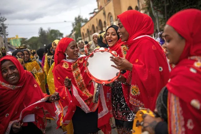 Young women dressed in traditional attires chant and dance during the celebration for the Shuwalid festival in Harar on April 16, 2024. Shuwalid is an annual festival celebrated by the Harari people of Ethiopia and marks the end of six days of fasting to compensate omissions during Ramadan. Founded in the 10th century, Harar – also called Jugol – is reputed to be one of the oldest cities in east Africa and the fourth holiest city in the Islamic world  – after Mecca, Medina and Jerusalem – with locals boasting it has the highest concentration of mosques and shrines in the world. The old town has been enclosed by a four-metre high wall since 1551 and mostly forbidden to non-Muslims until 1887 when it was conquered by Ethiopia's Emperor Menelik II. Long years of enclosure allowed Harari culture to flourish and its dwellers became famous for a modern trade system, hand-bound books, Islamic teaching, poetry and lively religious festivals, which make up Harar's unique identity. (Photo by Michele Spatari/AFP Photo)