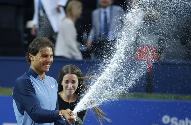 Spain's Rafael Nadal sprays sparkling wine as he celebrates after winning the Barcelona Open tennis tournament in Barcelona, Spain, Sunday, April 24, 2016. Spain's Rafael Nadal defeated Japan's Kei Nishikori 6-4 and 7-5, in the final. (Photo by Manu Fernandez/AP Photo)
