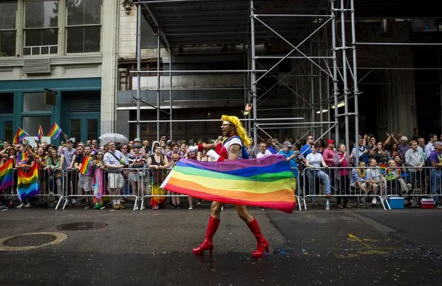 A man holding a rainbow flag takes part in the annual NYC Gay Pride parade in New York City June 28, 2015. (Photo by Eric Thayer/Reuters)