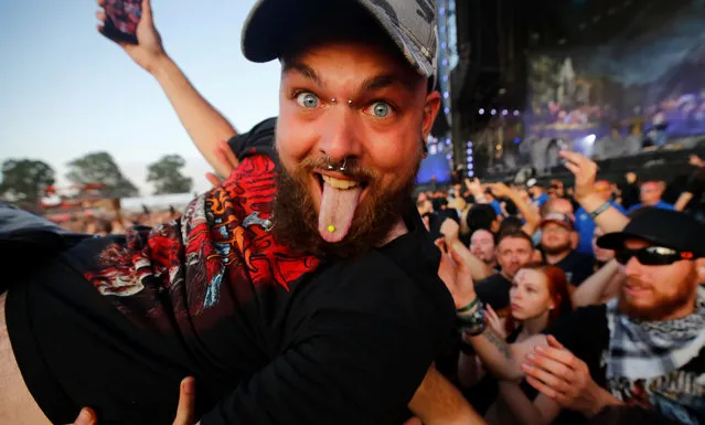A heavy metal fan sticks out his tongue as he surfs on top of the crowd during the performance of the German power metal band “Powerwolf” at the world's largest heavy metal festival, the Wacken Open Air 2019, in Wacken, Germany on August 3, 2019. (Photo by Wolfgang Rattay/Reuters)