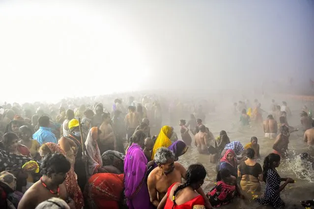 Hindu devotees take a holy dip at the Sangam, the confluence of the rivers Ganges and Yamuna and mythical Saraswati, on the auspicious bathing day of “Mauni Amavasya” during the annual Magh Mela festival in Allahabad, on February 1, 2022. (Photo by Sanjay Kanojia/AFP Photo)