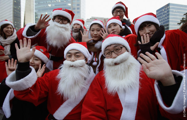 South Koreans wear Santa Claus outfits and hold gifts to promote Christmas at a charity event