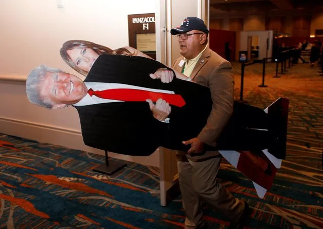 A man carries cutouts of former President Donald Trump and former first lady Melania Trump at the Conservative Political Action Conference (CPAC) in Orlando, Florida, U.S. February 24, 2022. (Photo by Octavio Jones/Reuters)