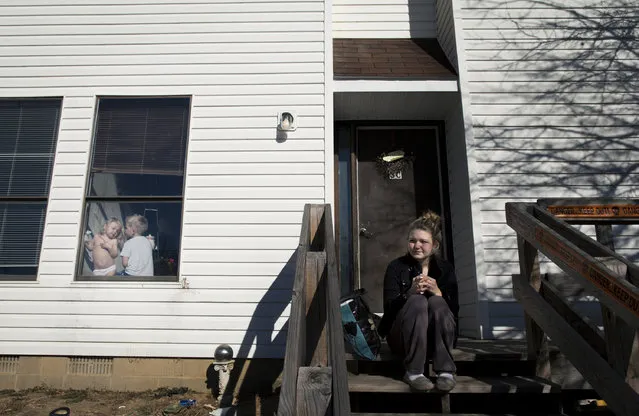 Maggie sat in front of her best friend Amy's house and smoked the morning after the assault, while Kayden and Amy's daughter Olivia, three, played in the window. A few days later, she decided to move to Alaska to be closer with her estranged husband and father of her children. Shane pled guilty to a count of domestic battery, and was given a nine month sentence. He was released in August 2013, five months later, on good behavior. (Photo by Sara Lewkowicz/Sony World Photography Awards)