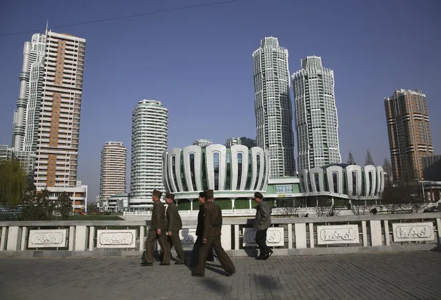 North Koreans walk past Ryomyong Street, the newest residential development on Tuesday, April 11, 2017, in Pyongyang, North Korea. North Korea will mark the 105th anniversary of the birth of late leader Kim Il Sung on April 15. (Photo by Wong Maye-E/AP Photo)