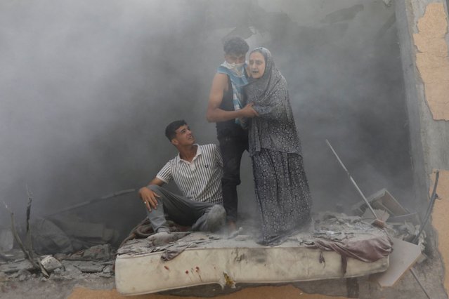 Palestinians react at the site of an Israeli strike on a house, amid the Israel-Hamas conflict, in Deir Al-Balah, in the central Gaza Strip, on June 14, 2024. (Photo by Abed Khaled/Reuters)