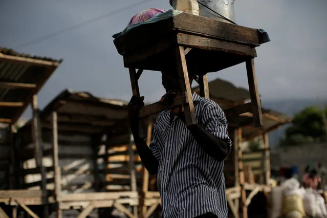 A street vendor carries his stand on his head as he walks in a market in Port-au-Prince, Haiti, February 14, 2017. (Photo by Andres Martinez Casares/Reuters)